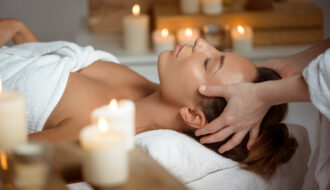 Femme recevant un head spa en institut de beauté dans une ambiance relaxante avec bougies