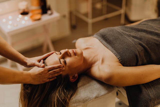 Prestation de head spa près de Cambrai : massage bien-être du visage et du cuir chevelu sous la lumière chaleureuse des bougies chez Lucie Concept Beauté.