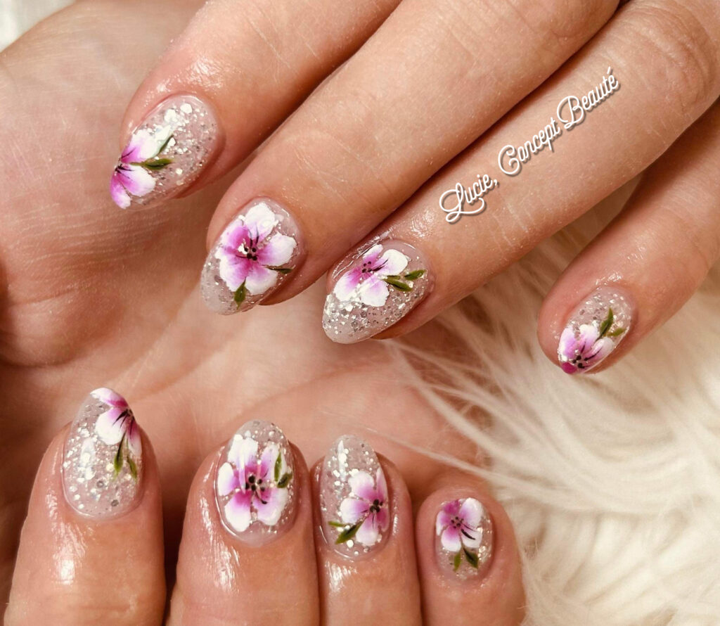 Nail art artistique avec fleurs roses peintes à la main et paillettes argentées par l'onglerie Lucie Concept Beauté à Caudry.