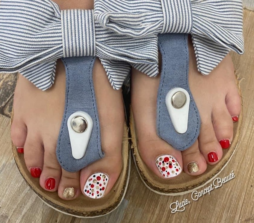 Beauté des pieds et pédicure avec vernis rouge et nail art à pois réalisée par l'onglerie Lucie Concept Beauté à Caudry.