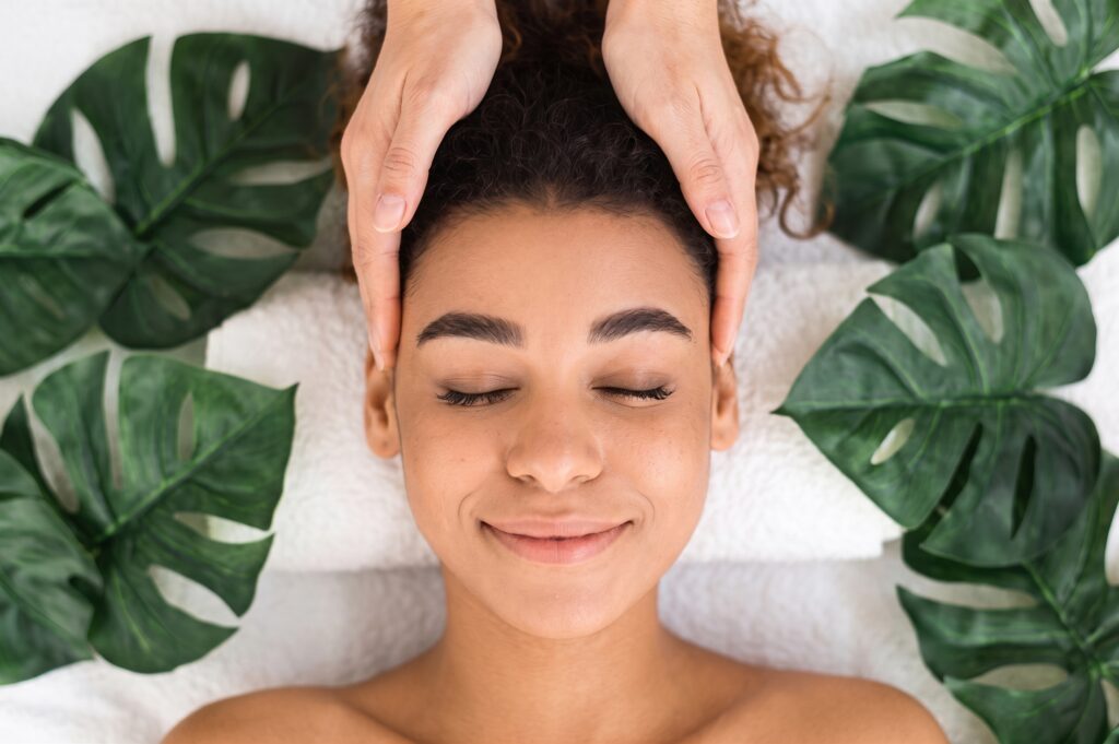 Modelage relaxant du visage et du cuir chevelu lors d'un soin du visage détente à Caudry
